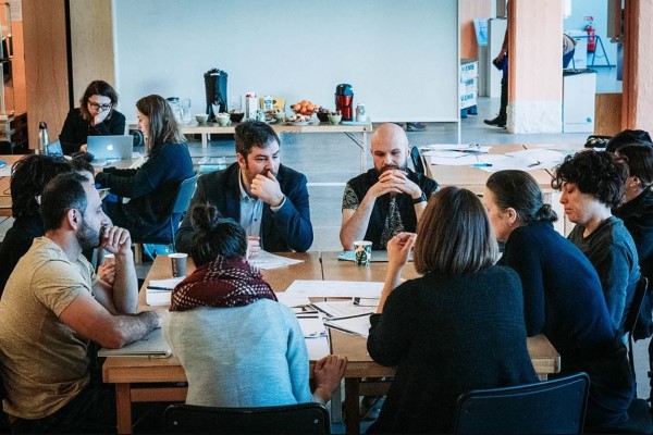 A group of teachers sitting at a table, talking to one another.