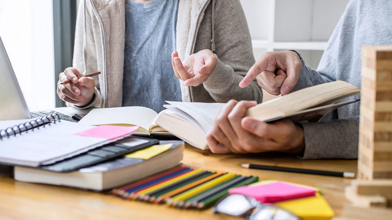 Hands with pens and books
