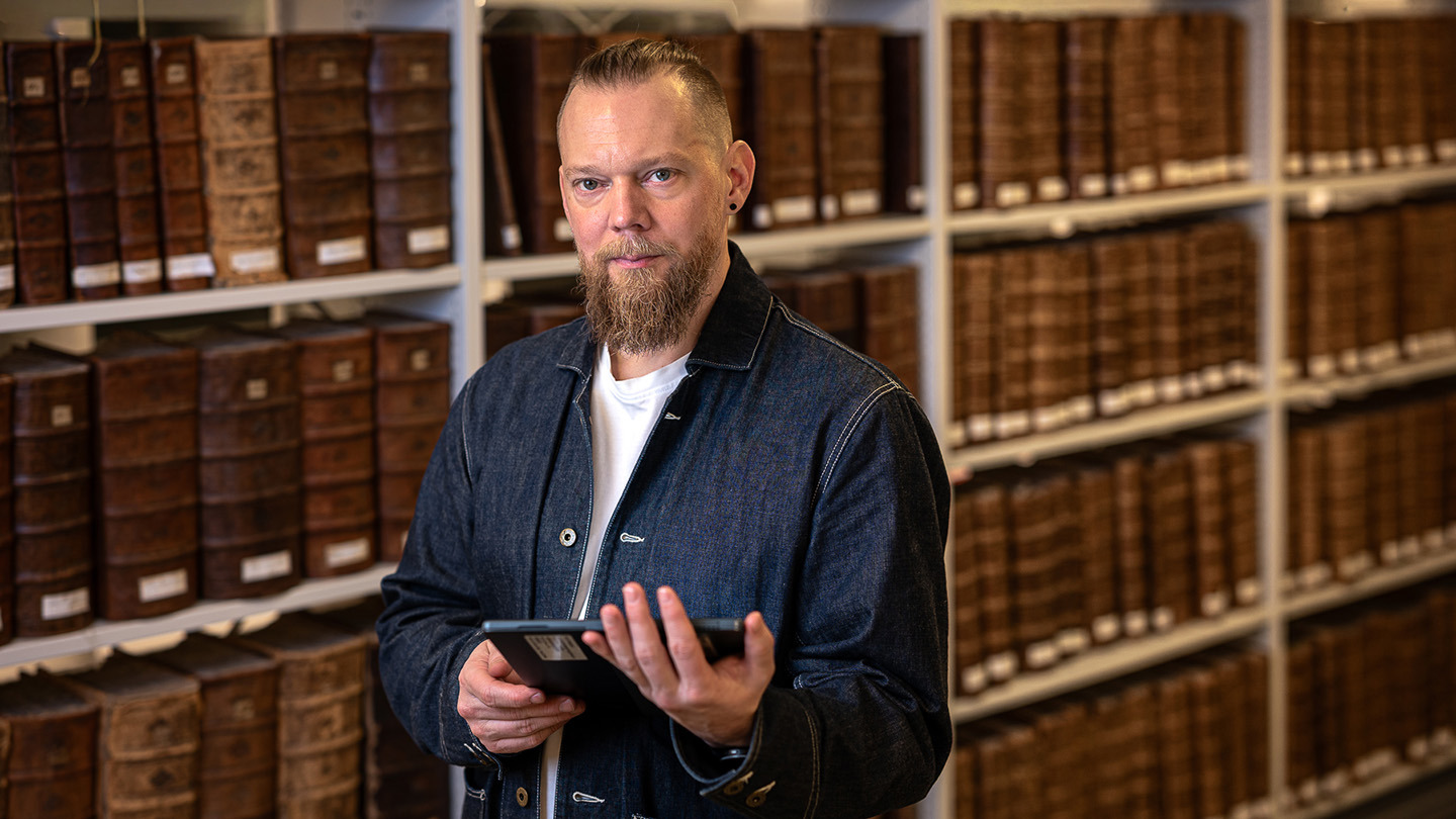 Porträtt Daniel Forsman i biblioteks- och arkivmiljö