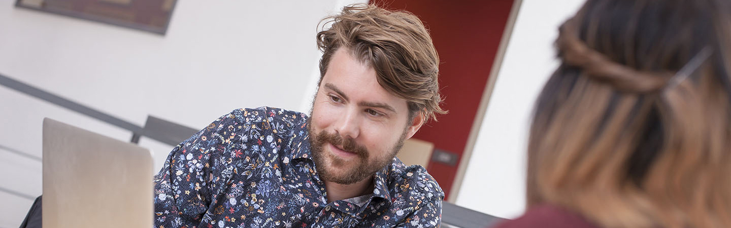 Två studenter sitter och pluggar i högskolebiblioteket.